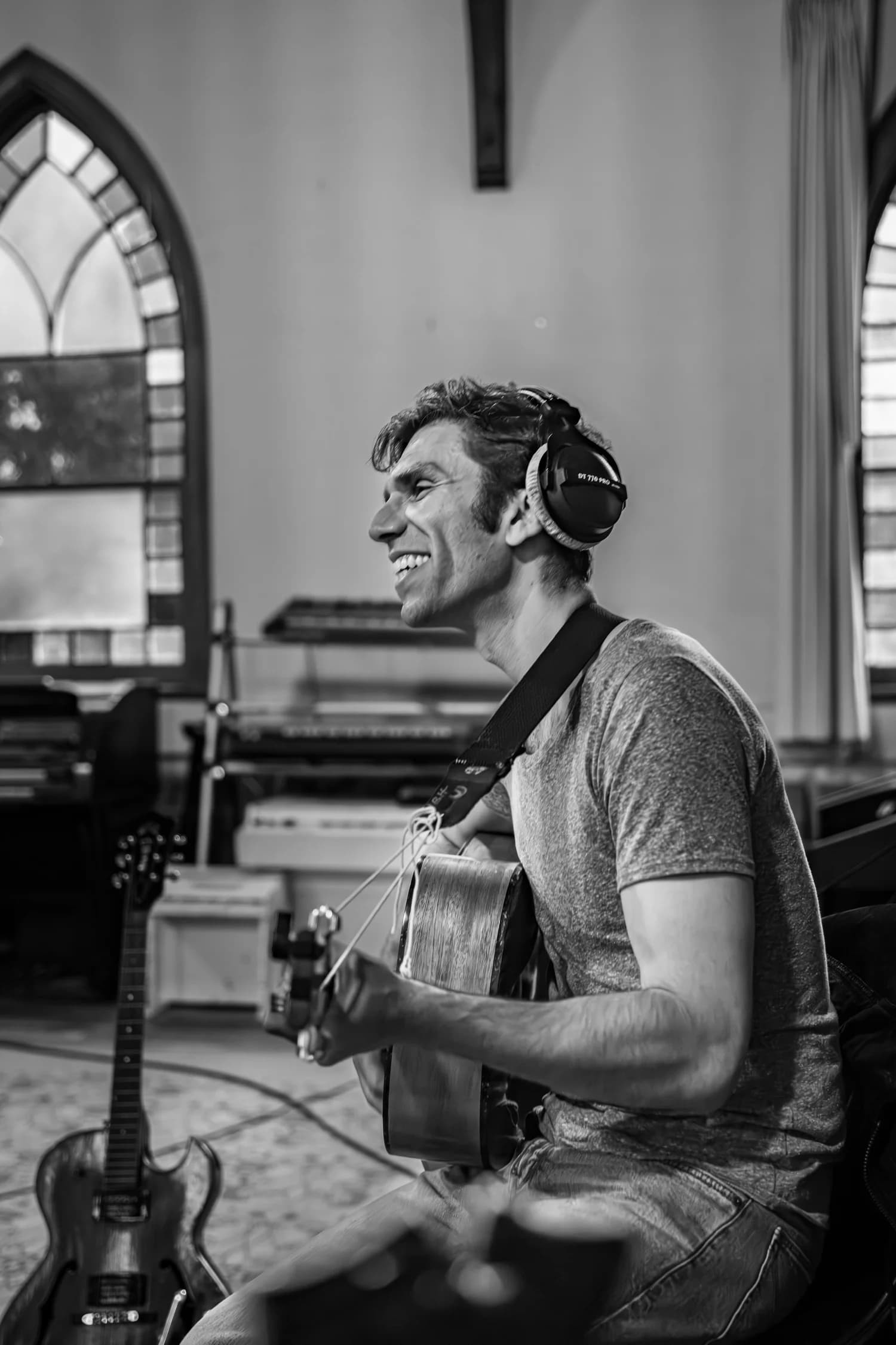 Sam Kogon recording guitar in a studio, black and white