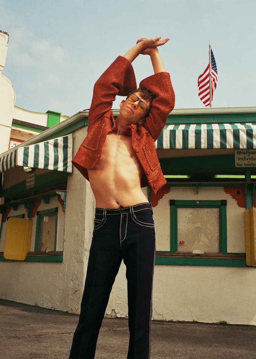 Sam Kogon in a red jacket under an American flag